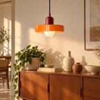 Suspension Vallauris bordeaux et orange au-dessus d'un buffet en bois