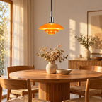 Suspension Menton chromé et orange au-dessus d'une table ronde