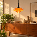 Suspension Menton noir et orange au-dessus d'un buffet en bois